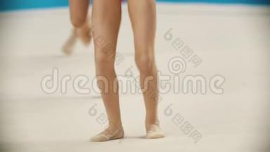 在<strong>艺术体操</strong>比赛中，年轻女子的腿-用球表演她们的外表